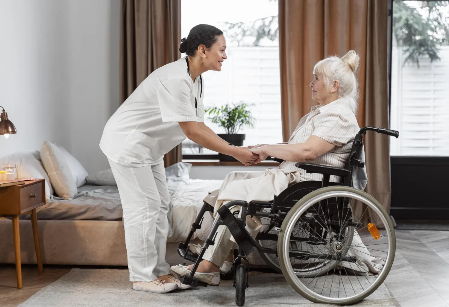 In Guten Händen - Krankenschwester hilft einer alten Frau im Rollstuhl