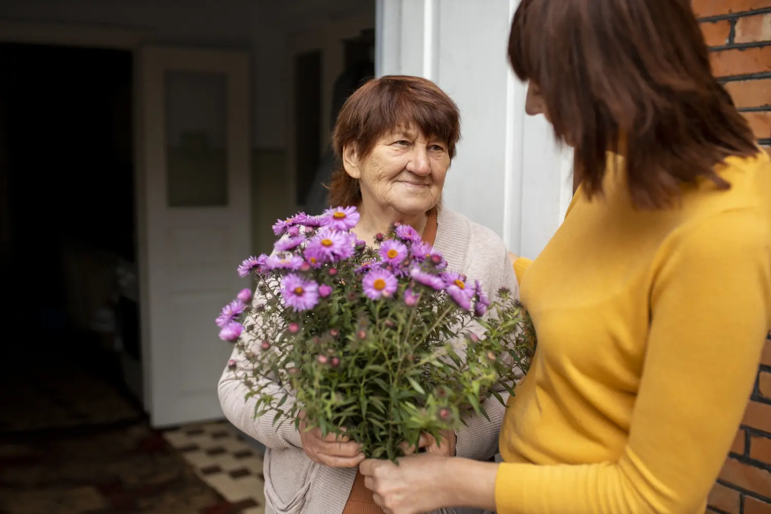 In Guten Händen - Krankenschwester schenkt einer alten Dame Blumen