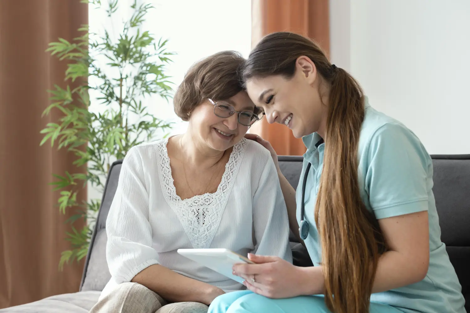 In Guten Händen - Krankenschwester und alte Frau sitzen zusammen